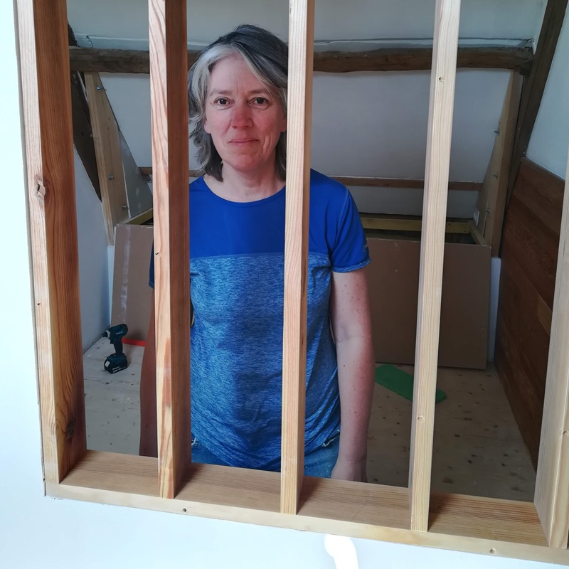 Woman standing behind wall divider